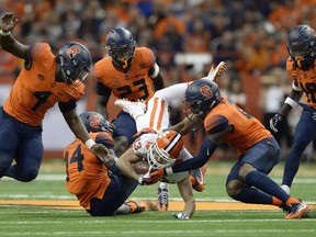 Clemson wide receiver Hunter Renfrow (13) is upended by Syracuse defensive back Evan Foster (14) and defensive back Jordan Martin (2) during the first half of an NCAA college football game, Friday, Oct. 13, 2017, in Syracuse, N.Y. (AP Photo/Adrian Kraus)