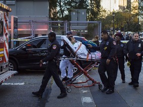 Emergency personnel carry a man into an ambulance after a motorist drove onto a busy bicycle path near the World Trade Center memorial and struck several people Tuesday, Oct. 31, 2017, in New York. (AP Photo/Andres Kudacki)