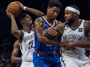 Brooklyn Nets' Caris Levert , left, drives to the basket in between players during the first half of a preseason NBA basketball game against New York Knicks, Sunday, Oct. 8, 2017, in New York. (AP Photo/Andres Kudacki)