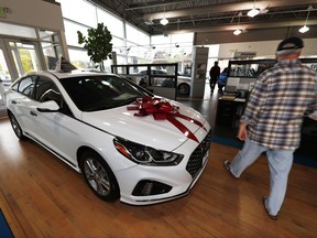 FILE - In this Friday, Oct. 6, 2017, file photo, a buyer walks past a 2018 Sonata sitting amid an assortment of models on the showroom floor of a Hyundai dealership in the south Denver suburb of Littleton, Colo. On Monday, Oct. 30, 2017, the Commerce Department issues its September report on consumer spending, which accounts for roughly 70 percent of U.S. economic activity. (AP Photo/David Zalubowski, File)