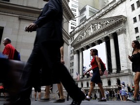 FILE - In this Monday, Aug. 24, 2015, file photo, people walk past the New York Stock Exchange. Congress is looking for ways to raise revenue, and one of the methods reportedly under consideration is to limit how much pre-tax money workers can contribute to their 401(k) and similar accounts. If it were to happen, the move would strike at a way that tens of millions of Americans use to save for retirement. (AP Photo/Seth Wenig, File)