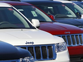 FILE - In this Nov. 30, 2010, file photo, a row of 2011 Jeep Grand Cherokee's sit at a dealership in Mesa, Ariz. Fiat Chrysler is recalling nearly 710,000 Jeep and Dodge SUVs in North America because an improperly installed brake shield could let water leak in and limit braking ability. The recall covers 2011 to 2014 Jeep Grand Cherokees and Dodge Durangos. (AP Photo/Matt York, File)