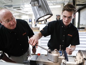 FILE - In this May 25, 2017, file photo, apprentice Ryan Buzzy, right, works with Skip Johnson, a trainer for the Stihl Inc. apprenticeship program, on a metalworking lathe in their training area at the Stihl Inc. manufacturing facility in Virginia Beach, Va. On Thursday, Oct. 5, 2017, the Commerce Department reports on U.S. factory orders for August. (AP Photo/John Minchillo, File)