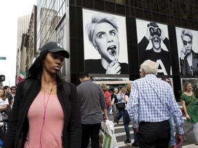 In this Monday, Oct. 23, 2017, photo, pedestrians walk by advertising for the Armani Exchange store on New York's Fifth Avenue. Diversity in the advertising industry is becoming a higher priority for consumer product companies as they try to reach a new generation of customers with evolving sensibilities on ethnicity, age, gender and sexuality. (AP Photo/Mark Lennihan)