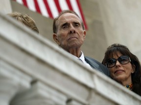 FILE - In this May 29, 2017 file photo former Republican presidential candidate and U.S. Senate Majority Leader Sen. Bob Dole watches as President Donald Trump speaks during a Memorial Day ceremony at Arlington National Cemetery, in Arlington, Va. Dole has returned home after being hospitalized for three weeks with low blood pressure. Dole spokeswoman Marion Watkins said in an email Tuesday, Oct. 10 that the 94-year-old former Kansas senator was discharged Thursday, Oct. 5 from the Walter Reed National Military Medical Center outside Washington, D.C.  (AP Photo/Evan Vucci, File)