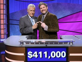 CORRECTS LAST NAME TO TREBEK INSTEAD OF TREBEC  This image released by Jeopardy Productions, Inc. shows "Jeopardy!" host Alex Trebek, left, and contestant Austin Rogers, whose 12-game winning streak came to an end on Thursday's broadcast. Rogers finished his run in fifth place on the all-time regular-season (non-tournament), winning $411,000. (Carol Kaelson/Jeopardy Productions, Inc. via AP)