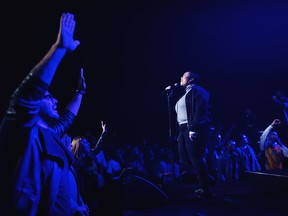 In this Oct. 22, 2017 photo, people attend a service at Hillsong Church in New York. Hillsong is known for its Christian rock style of music and tattooed leaders like pastor Carl Lentz, who counts singer Justin Bieber and NBA stars Kyrie Irving and Kevin Durant among his followers. (AP Photo/Andres Kudacki)