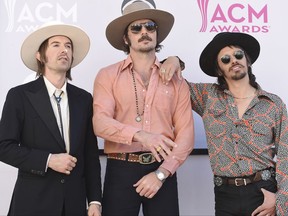 FILE - In this April 2, 2017 file photo, Jess Carson, from left, Mark Wystrach, and Cameron Duddy, of the musical group Midland, arrive at the 52nd annual Academy of Country Music Awards in Las Vegas. The trio said they have been inspired by all eras of music, from Nirvana and Paul Simon to Hank Williams Sr. and Otis Redding. Wystrach, the lead singer, said they wanted to write songs that stood the test of time and weren't disposable. (Photo by Jordan Strauss/Invision/AP, File)