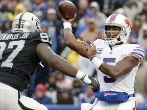 Buffalo Bills quarterback Tyrod Taylor (5) throws a pass as Oakland Raiders defensive end Mario Edwards (97) rushes in during the first half of an NFL football game, Sunday, Oct. 29, 2017, in Orchard Park, N.J. (AP Photo/Adrian Kraus)