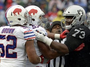 Umpire Shawn Smith, center right, tries to break up an argument between Oakland Raiders offensive tackle Marshall Newhouse (73) and Buffalo Bills middle linebacker Preston Brown (52) and outside linebacker Lorenzo Alexander (57) during the first half of an NFL football game, Sunday, Oct. 29, 2017, in Orchard Park, N.J. (AP Photo/Adrian Kraus)