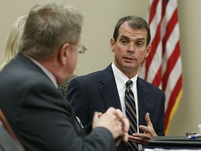 FILE- In this Oct. 13, 2014, file photo, Oklahoma's health commissioner, Dr. Terry Cline, right, speaks during a news conference in Oklahoma City. Cline has resigned as Oklahoma's state health commissioner after the board accused him of mismanaging the health department's finances. The board voted at an emergency meeting Monday, Oct. 30, 2017, to accept Cline's resignation and appoint its finance secretary, Preston Doerflinger, as interim commissioner. (AP Photo/Sue Ogrocki, File)