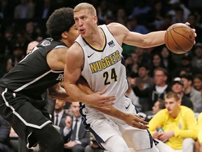 Brooklyn Nets center Jarrett Allen, left, becomes entangled with Denver Nuggets center Mason Plumlee (24) as Plumlee drives toward the basket during the first half of an NBA basketball game, Sunday, Oct. 29, 2017, in New York. (AP Photo/Kathy Willens)