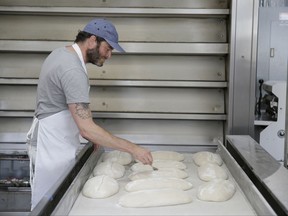 In this photo taken Friday, Aug. 11, 2017, Chad Robertson prepares loaves of bread dough to be baked at the Tartine Manufactory in San Francisco. For a bread lover, no destination is more alluring than San Francisco. (AP Photo/Eric Risberg)