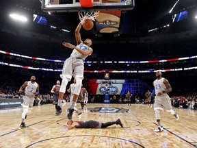 FILE- In this Feb. 20, 2017, file pool photo, Eastern Conference small forward Giannis Antetokounmpo, of the Milwaukee Bucks, dunks as Western Conference guard Stephen Curry, bottom, of the Golden State Warriors, lies on the court during the first half of the NBA All-Star basketball game in New Orleans. The NBA is scrapping the East against West format for its All-Star Game and will have captains pick teams this season. (AP Photo/Max Becherer, Pool, File)