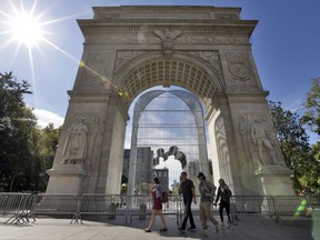 People walk by "Arch," by Chinese activist artist Ai Weiwei, inside the Washington Square Arch, in New York's Greenwich Village, part of his "Good Fences Make Good Neighbors" installations, Tuesday, Oct. 10, 2017. The citywide exhibition, presented by Public Art Fund, will be on view at over 300 sites, including large-scale works in Central Park, and the Unisphere in Queens.(AP Photo/Richard Drew)