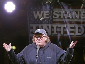 File- This Jan. 19, 2017, file photo shows  filmmaker Michael Moore speaking to thousands of people at an anti-Trump rally and protest in front of the Trump International Hotel in New York. President Donald Trump has set his sights on a new target: filmmaker and Trump critic Moore. Trump tweets: "While not at all presidential I must point out that the Sloppy Michael Moore Show on Broadway was a TOTAL BOMB and was forced to close. Sad!" Trump criticized the liberal activist on Saturday, Oct. 28, 2017, several days after Moore's one-man show, "The Terms of My Surrender," concluded its limited Broadway run on Oct. 22. (AP Photo/Kathy Willens. File)