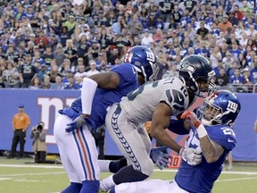 New York Giants' Eli Apple, left, and Darian Thompson, right, break up a pass intended for Seattle Seahawks' Tyler Lockett, center, during the first half of an NFL football game, Sunday, Oct. 22, 2017, in East Rutherford, N.J. (AP Photo/Bill Kostroun)