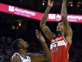 Washington Wizards' Kelly Oubre Jr., right, shoots over Golden State Warriors' Kevin Durant (35) during the first half of an NBA basketball game Friday, Oct. 27, 2017, in Oakland, Calif. (AP Photo/Ben Margot)