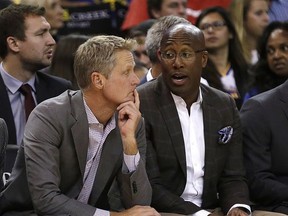 Golden State Warriors coach Steve Kerr, left, sits beside assistant coach Mike Brown during the first half of a preseason NBA basketball game against the Denver Nuggets Saturday, Sept. 30, 2017, in Oakland, Calif. (AP Photo/Ben Margot)