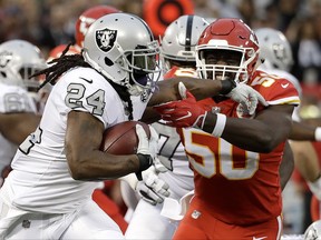 Oakland Raiders running back Marshawn Lynch (24) runs against Kansas City Chiefs outside linebacker Justin Houston (50) during the first half of an NFL football game in Oakland, Calif., Thursday, Oct. 19, 2017. (AP Photo/Marcio Jose Sanchez)