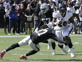 Baltimore Ravens running back Terrance West (28) runs against Oakland Raiders free safety Reggie Nelson (27) during the first half of an NFL football game in Oakland, Calif., Sunday, Oct. 8, 2017. (AP Photo/Ben Margot)