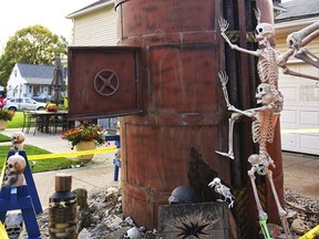 In an Oct. 12, 2017 photo, Ricky and Marlene Rodriguez's home at the corner of 30th St. and Tacoma Ave., in Lorain, Ohio, has morphed from a pirate ship, to a train and now into a digging machine poking through the home's driveway. The home is an annual attraction for neighbors and passersby within the city.  (Kristin Bauer/Chronicle-Telegram via AP)