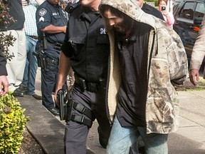 Suspect Arron Lawson, 23, is escorted into the Lawrence County Courthouse, Friday, Oct. 13, 2017 by Sheriff Jeff Lawless, left, of the Lawrence County Sheriff's Office in Ironton, Ohio. He was arrested roughly 12 miles (19 kilometers) south of where authorities found three adults dead in a house trailer on Wednesday evening.(Jessica St. James/Ironton Tribune via AP)