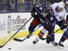 Columbus Blue Jackets' Zach Werenski, left, tries to control the puck as New York Islanders' Casey Cizikas defends during the first period of an NHL hockey game Friday, Oct. 6, 2017, in Columbus, Ohio. (AP Photo/Jay LaPrete)