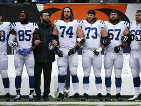 Indianapolis Colts quarterback Andrew Luck, third from left, locks arms with teammates as the national anthem plays before an NFL football game against the Cincinnati Bengals, Sunday, Oct. 29, 2017, in Cincinnati. (AP Photo/Frank Victores)