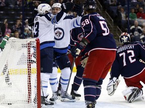 Winnipeg Jets forward Brandon Tanev (13) celebrates his goal against the Columbus Blue Jackets with teammate forward Shawn Matthias (16) behind Blue Jackets defenseman David Savard (58) and goalie Sergei Bobrovsky (72), of Russia, during the first period of an NHL hockey game in Columbus, Ohio, Friday, Oct. 27, 2017. (AP Photo/Paul Vernon)