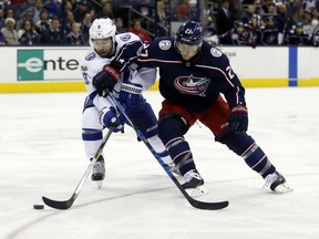 Tampa Bay Lightning forward Tyler Johnson, left, tries to control the puck against Columbus Blue Jackets defenseman Ryan Murray during the first period of an NHL hockey game in Columbus, Ohio, Thursday, Oct. 19, 2017. (AP Photo/Paul Vernon)