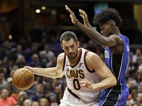 Cleveland Cavaliers' Kevin Love, left, drives past Orlando Magic's Jonathan Isaac in the first half of an NBA basketball game, Saturday, Oct. 21, 2017, in Cleveland. (AP Photo/Tony Dejak)