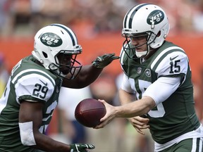 New York Jets quarterback Josh McCown, right, hands off the ball to running back Bilal Powell during the first half of an NFL football game against the Cleveland Browns, Sunday, Oct. 8, 2017, in Cleveland. (AP Photo/David Richard)
