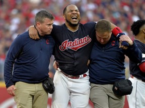 Cleveland Indians' Edwin Encarnacion is carried off the field after rolling his ankle at second base in the second inning of Game 2 of baseball's American League Division Series against the New York Yankees, Friday, Oct. 6, 2017, in Cleveland. (AP Photo/Phil Long)