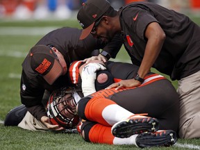 Trainers, top, check Cleveland Browns tackle Joe Thomas after Thomas was hurt in the second half of an NFL football game against the Tennessee Titans, Sunday, Oct. 22, 2017, in Cleveland. (AP Photo/Ron Schwane)