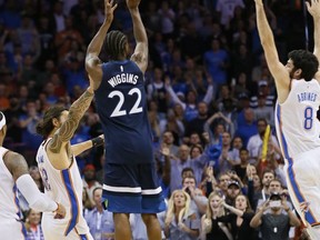Minnesota Timberwolves guard Andrew Wiggins (22) shoots the game winning shot between Oklahoma City Thunder center Steven Adams (12) and guard Alex Abrines (8) in the fourth quarter of an NBA basketball game in Oklahoma City, Sunday, Oct. 22, 2017. Minnesota won 115-113. (AP Photo/Sue Ogrocki)