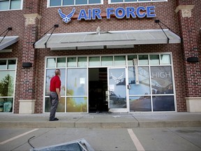 FILE - In a Tuesday, July 11, 2017 file photo, Indrek Redard, who works for the property management company, views damage, after an explosion Monday night outside an Air Force recruitment office in Bixby, Okla. The center was closed at the time and no one was injured. Attacks this summer on counter-protesters in Charlottesville, Virginia, and the empty Air Force recruiting station in Oklahoma had the hallmarks of terrorist attacks. But they weren't prosecuted as such. (Mike Simons//Tulsa World via AP, File)