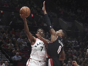 Toronto Raptors guard Kyle Lowry drives to the basket on Portland Trail Blazers guard Damian Lillard during the first quarter of an NBA basketball game in Portland, Ore., Monday, Oct. 30, 2017. (AP Photo/Steve Dykes)