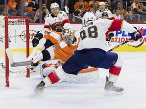 Philadelphia Flyers' Michal Neuvirth, of the Czech Republic, left, unable to stop the power play shot by Florida Panthers' Jamie McGinn, right, for a goal during the third period of an NHL hockey game, Tuesday, Oct. 17, 2017, in Philadelphia. The Flyers won 5-1. (AP Photo/Chris Szagola)