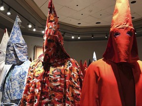 In this Sept. 21, 2017 photo, KKK robes are on display as part of Baltimore artist Paul Rucker's installation entitled "Rewind," now installed at York College's Wolf Hall in York, Pa. The college barred the public from seeing the art exhibition on slavery, white supremacy and racist violence against blacks, deeming it "potentially disturbing to some." (Ivey DeJesus/PennLive.com via AP)