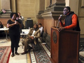 Philadelphia City Councilman Curtis Jones Jr., seated center, listens to Black Lives Matter Pennsylvania activist Asa Khalif, Tuesday Oct. 31, 2017, in Philadelphia City Hall. Activists, including Khalif, disrupted a poverty lesson at Philadelphia City Hall and got Jones, the organizer of the event, to instead go on a tour of one of the city's poorest neighborhoods. (AP Photo/Jacqueline Larma)