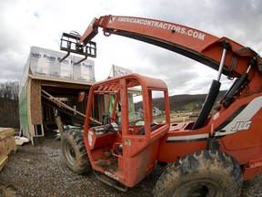 In this Wednesday, March 1, 2017, photo taken with a fisheye lens, a forklift is parked in front of one of the houses under construction in Zelienople, Pa. On Wednesday, Oct. 18, 2017, the Commerce Department reports on U.S. home construction in September. (AP Photo/Keith Srakocic)