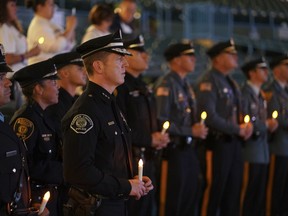 Camden County Chief of Police Scott Thomson, center, along with officers from other agencies participate in a candlelight vigil at Camden's waterfront stadium in remembrance of those who have died from drug overdoses, Saturday Oct. 14, 2017, in Camden, N.J. Speakers talked about the stigma of opioid addiction and the need to treat it as if it were like other chronic illnesses. (Joseph Kaczmarek/The Philadelphia Inquirer via AP)