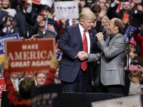 FILE - In this March 15, 2017, file photo, President Donald Trump shakes hands with singer Lee Greenwood as Greenwood sings "God Bless the USA" at a rally in Nashville, Tenn. A "happy birthday" tweet from President Donald Trump to Greenwood on Oct. 27, 2017, went off course after Trump mentioned the wrong Twitter user. (AP Photo/Mark Humphrey, File)