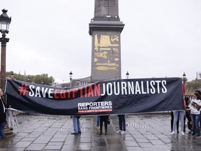 Activists of French watchdog Reporters without Borders hold a banner at the obelisk of the Place de la Concorde in Paris, Tuesday Oct.24, 2017. Egyptian President Abdel-Fattah el-Sissi is starting a three-day visit to France, where human rights are expected to be discussed along with economic and military cooperation. (AP Photo/Kamil Zihnioglu)