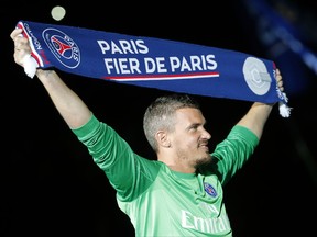 FILE - In this May 17, 2014 file photo, then Paris Saint Germain's goalkeeper Nicolas Douchez hold banner "Paris, proud of Paris" as he celebrates PSG's French League One title, at the Parc des Princes Stadium, in Paris. French officials say Lens goalkeeper Nicolas Douchez is in police custody Friday Oct.27, 2017 for alleged violence against his partner, with a newspaper reporting that she was found naked, bruised and bloody in a Paris apartment. (AP Photo/Jacques Brinon, File)