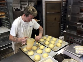 An apprentice prepartes pastries in a Paris bakery, Friday, Oct.20, 2017. French pastries and butter have become so popular abroad that the increased demand led to a mini shortage of the dairy product in French supermarkets. (AP Photo/Bertrand Combaldieu)