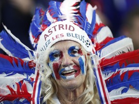 A woman who supports France smiles before the World Cup Group A qualifying soccer match between France and Belarus at the Stade de France stadium in Saint-Denis, outside Paris, Tuesday, Oct.10, 2017. (AP Photo/Christophe Ena)