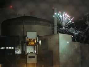 In this photo provided by Greenpeace France and dated Thursday, Oct. 12, 2017, Greenpeace activists set off fireworks inside the nuclear power plant of Cattenom, eastern France. Eight environmental activists are in custody after breaking into a French nuclear power station and setting off fireworks, in a bid to urge better protection for nuclear waste and protest France's dependence on atomic energy. (Greenpeace via AP)