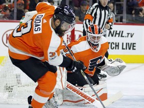 Philadelphia Flyers' Radko Gudas, left, clears the puck near goalie Brian Elliott during the first period of an NHL hockey game against the Edmonton Oilers, Saturday, Oct. 2119, 2017, in Philadelphia. (AP Photo/Tom Mihalek)